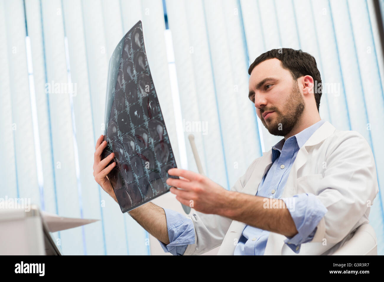 Junge männliche Arzt lesen und Überprüfung einen MRI Gehirn-scan Stockfoto
