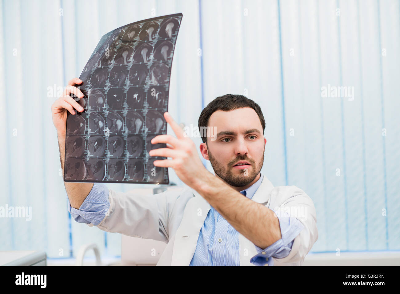 Closeup Portrait des Pflegepersonals intellektuellen Mann mit weißen Laborkittel Gehirn Röntgen Röntgenbild, Ct-Scan, mri, Klinik-Office-Hintergrund zu betrachten. Radiologie Stockfoto