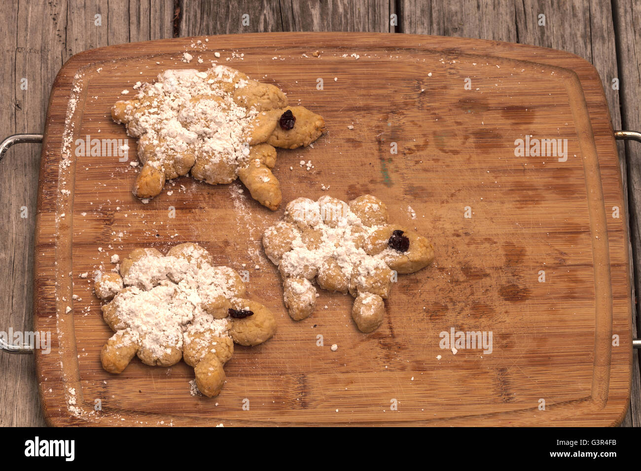 Brotbacken-Serie.  Brot-Schaf mit Puderzucker und getrockneten Kirschen Augen auf ein Holz Schneidebrett. Stockfoto
