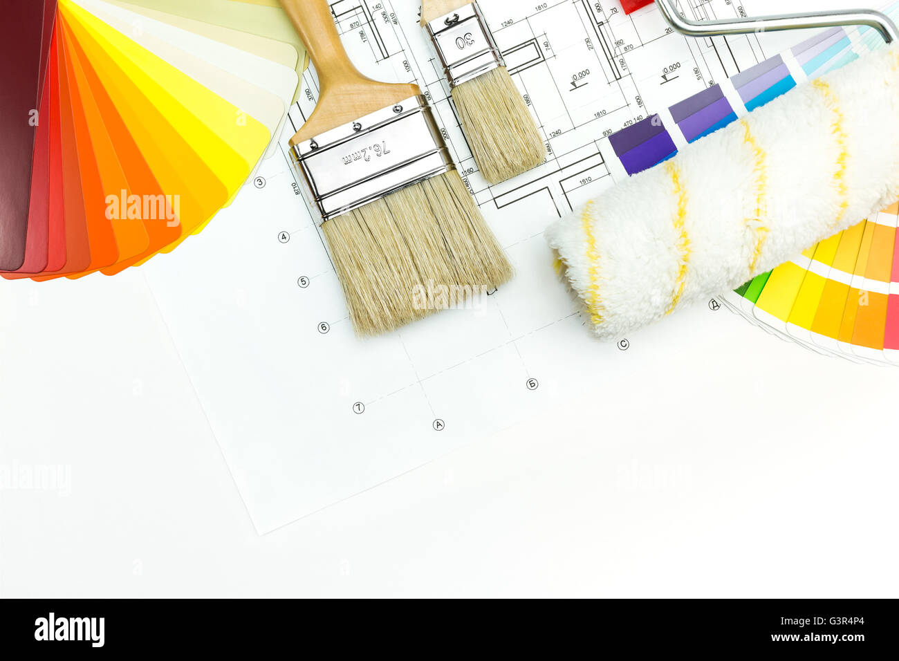 Farbroller, Pinsel und Farbe Führer auf Bauzeichnungen Hintergrund Stockfoto
