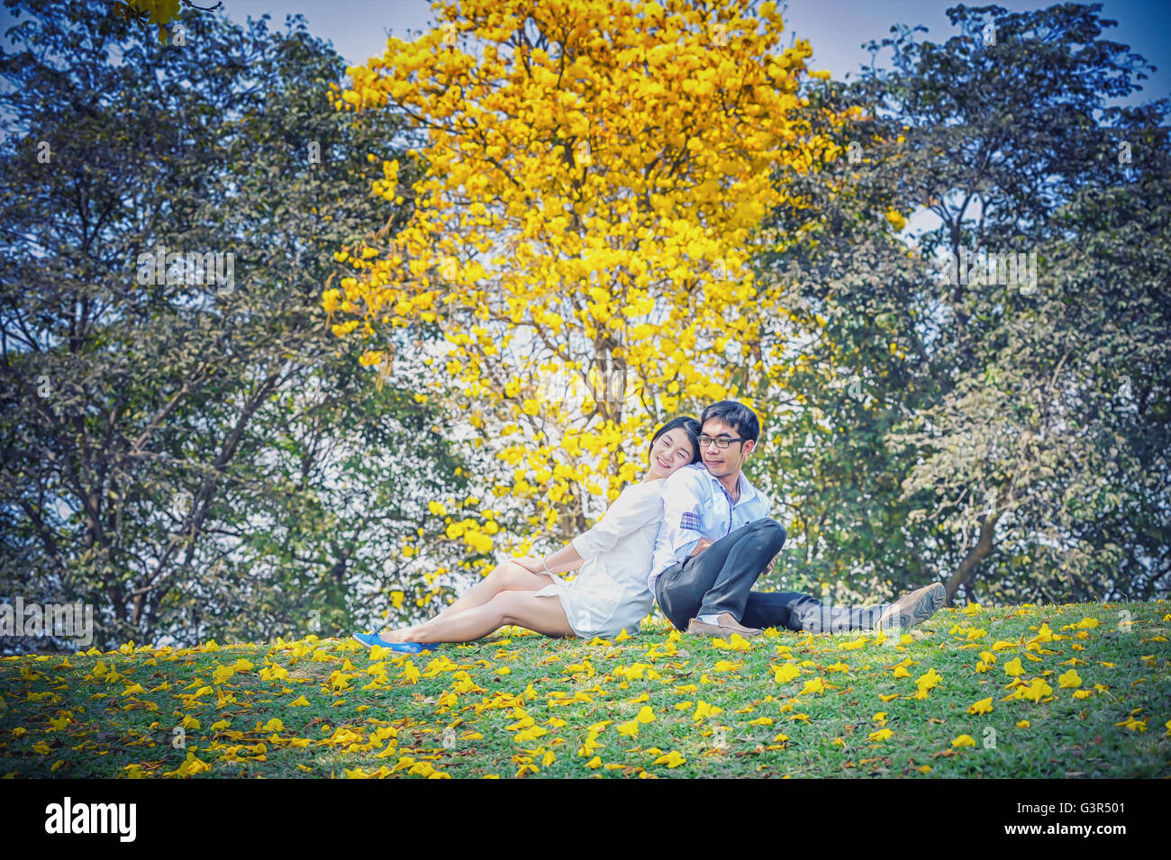 Porträt von Asien schöne junge Paar Rücken an Rücken unter Baum Stockfoto