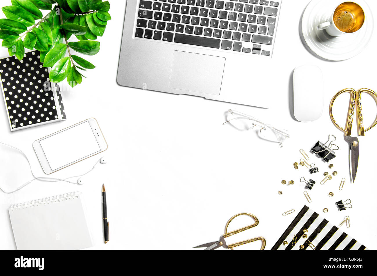 Arbeitsplatz mit Laptop, digital Telefon, Büromaterial, Notizbuch, Kaffee, grüne Pflanze. Kreative Arbeiten Schreibtisch weiß-Hintergrund Stockfoto