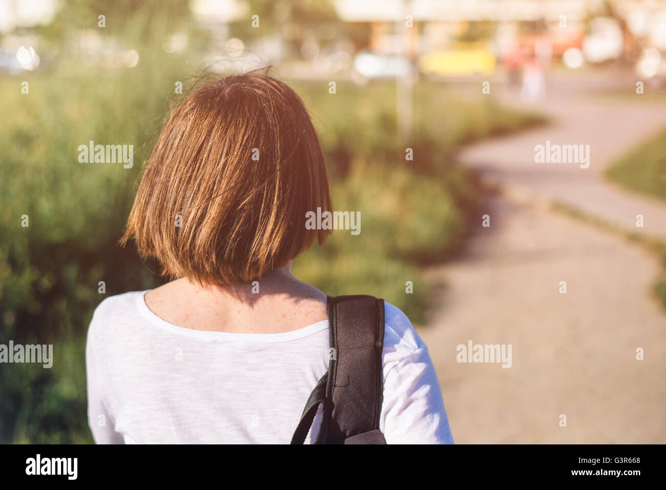 Lässige gewöhnliche junge Frau im Alltag zu Fuß auf den Straßen der Stadt, von hinten, selektiven Fokus Stockfoto