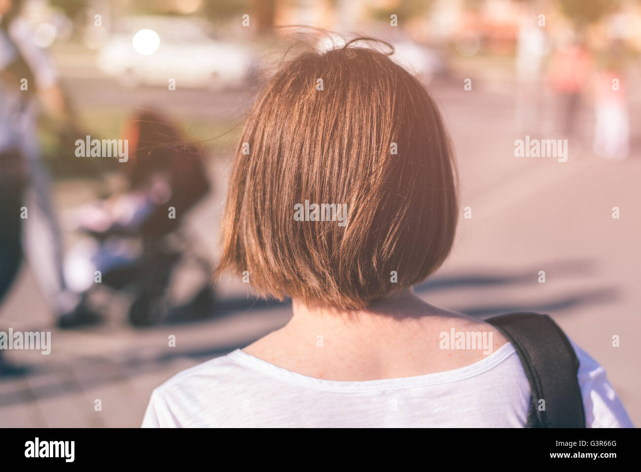Lässige junge Frau zu Fuß auf Straßen der Stadt als gewöhnlicher Alltag, von hinten, selektiven Fokus Stockfoto