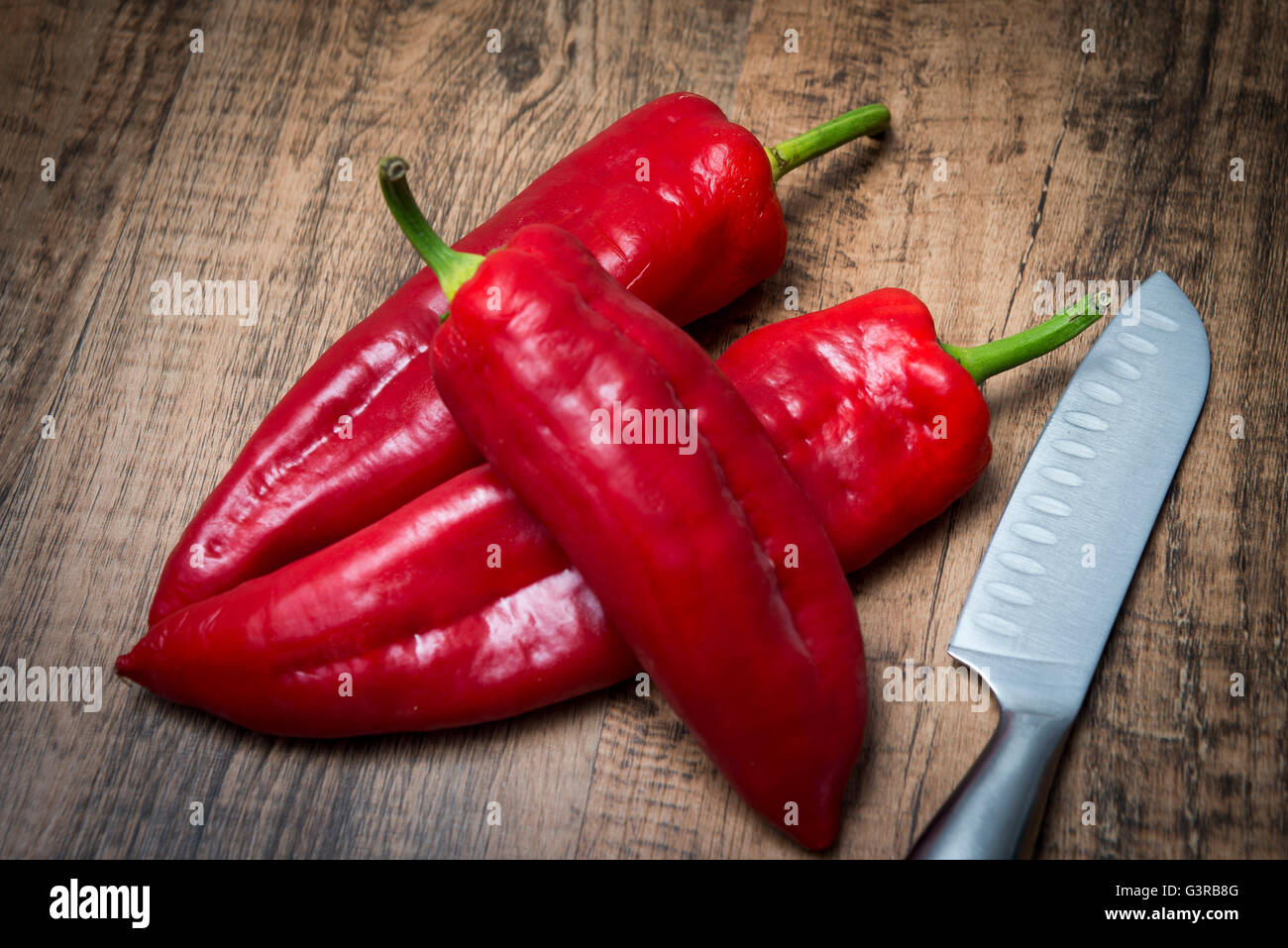 rote Spitzen Paprika und Messer auf Schneidebrett Stockfoto