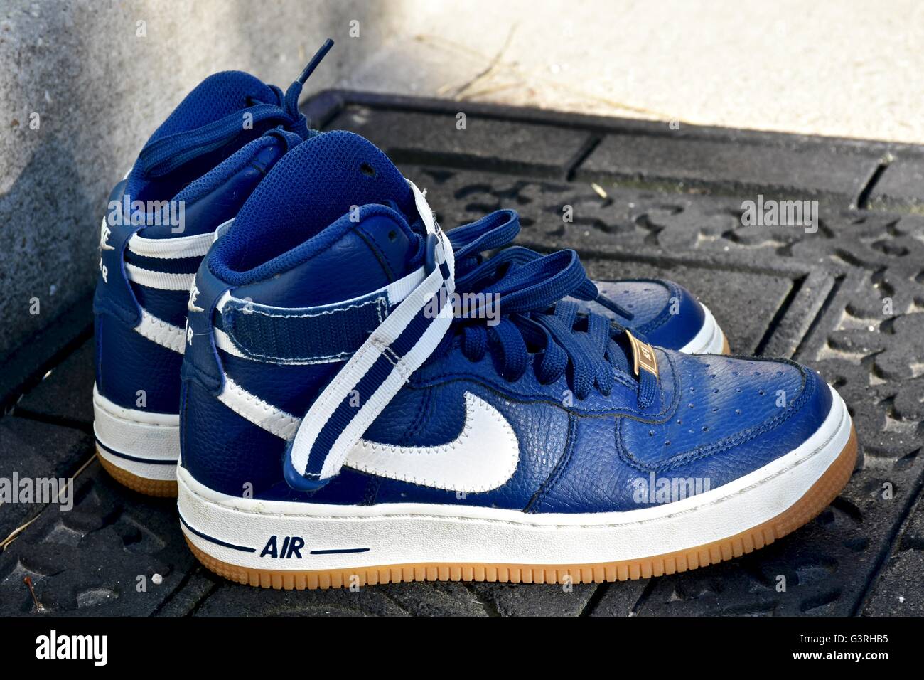 Ein paar blaue Nike Schuhe sitzen auf einer Fußmatte vor einem Haus  Stockfotografie - Alamy