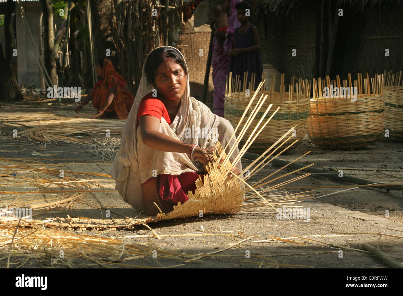 Eine Frau macht einen Bambuskorb. Mangla, Bangladesch. Stockfoto