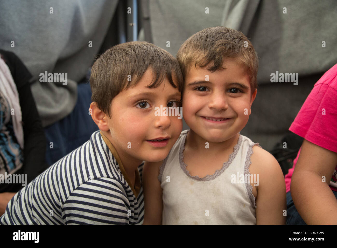 Syrische Flüchtlingskinder Lächeln für die Kamera im Idomeni Lager an der Grenze zwischen Griechenland und Mazedonien. Stockfoto