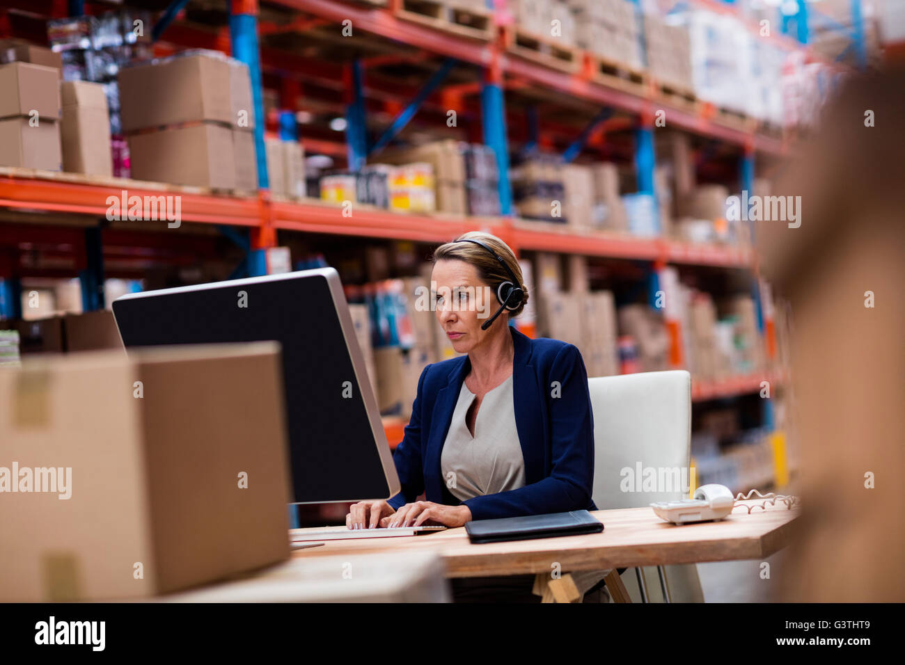 Auf ihrem Computerschreibtisch arbeiten Lagerleiter Stockfoto