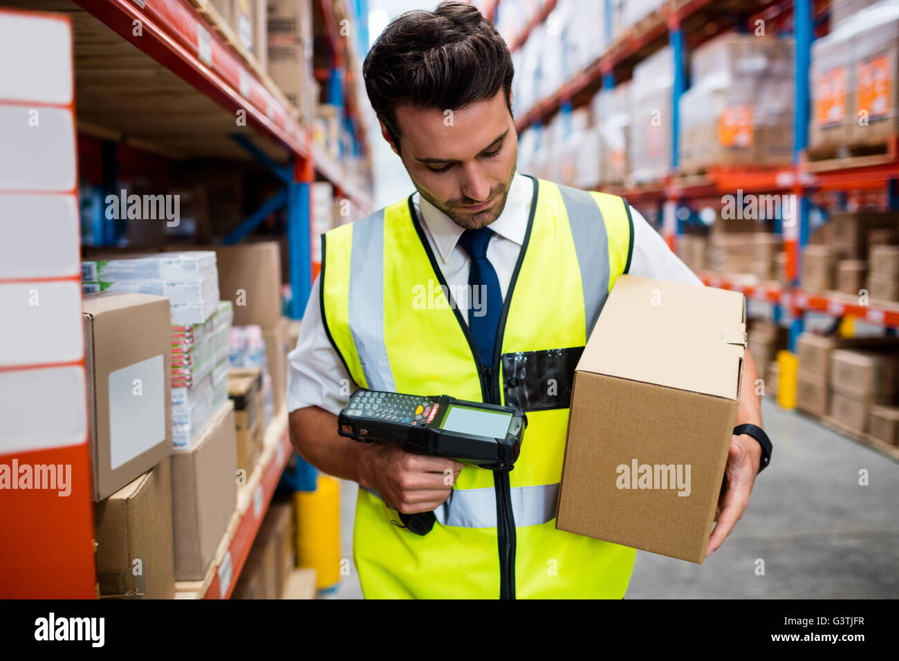 Warehouse Manager mit gelben Mantel Scannen von Barcodes auf box Stockfoto