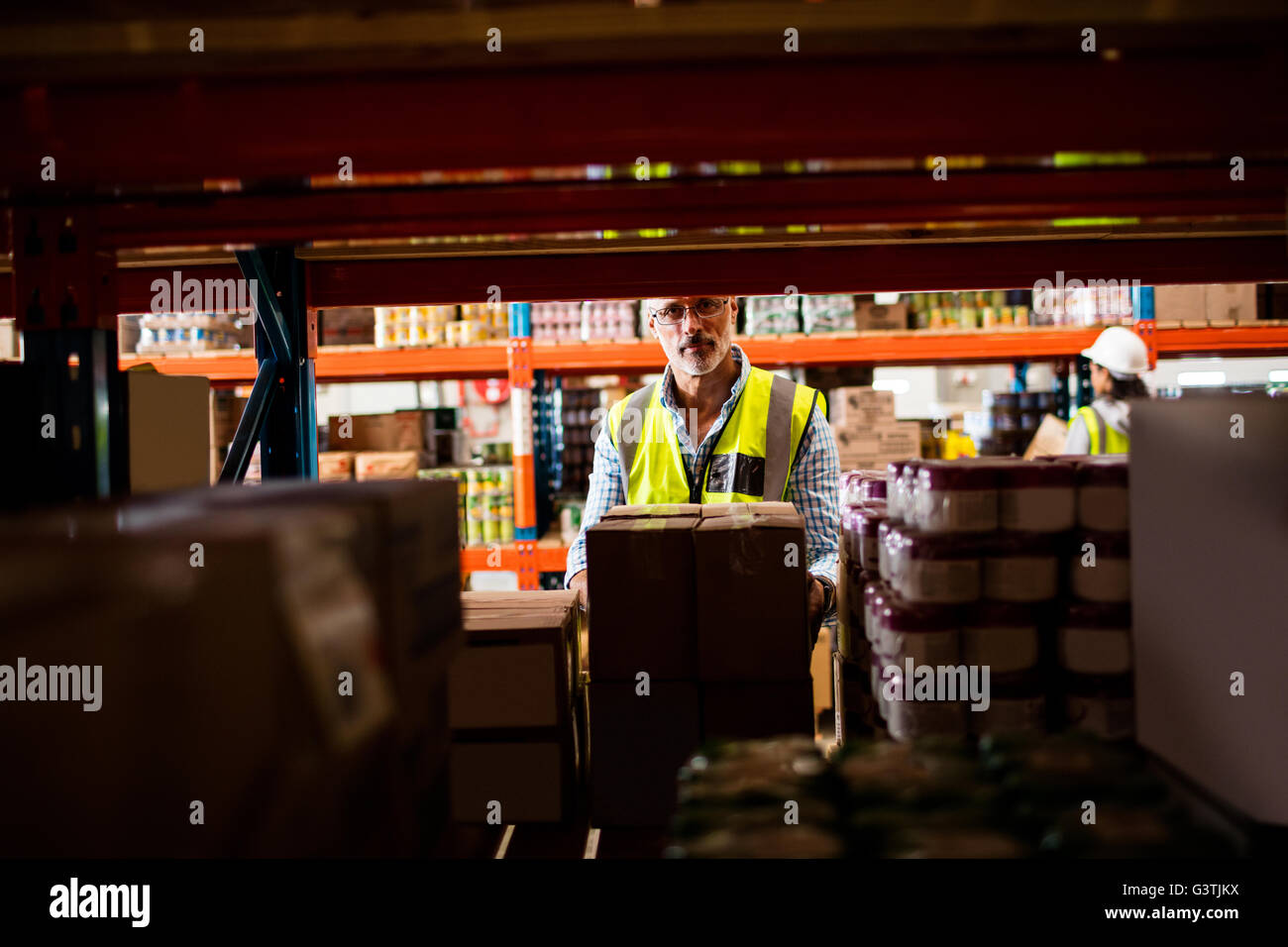 Arbeiter Warehouse posieren hinter Regalen Stockfoto