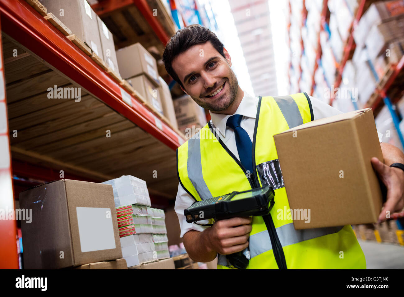Warehouse Manager mit gelben Mantel Scannen von Barcodes auf box Stockfoto