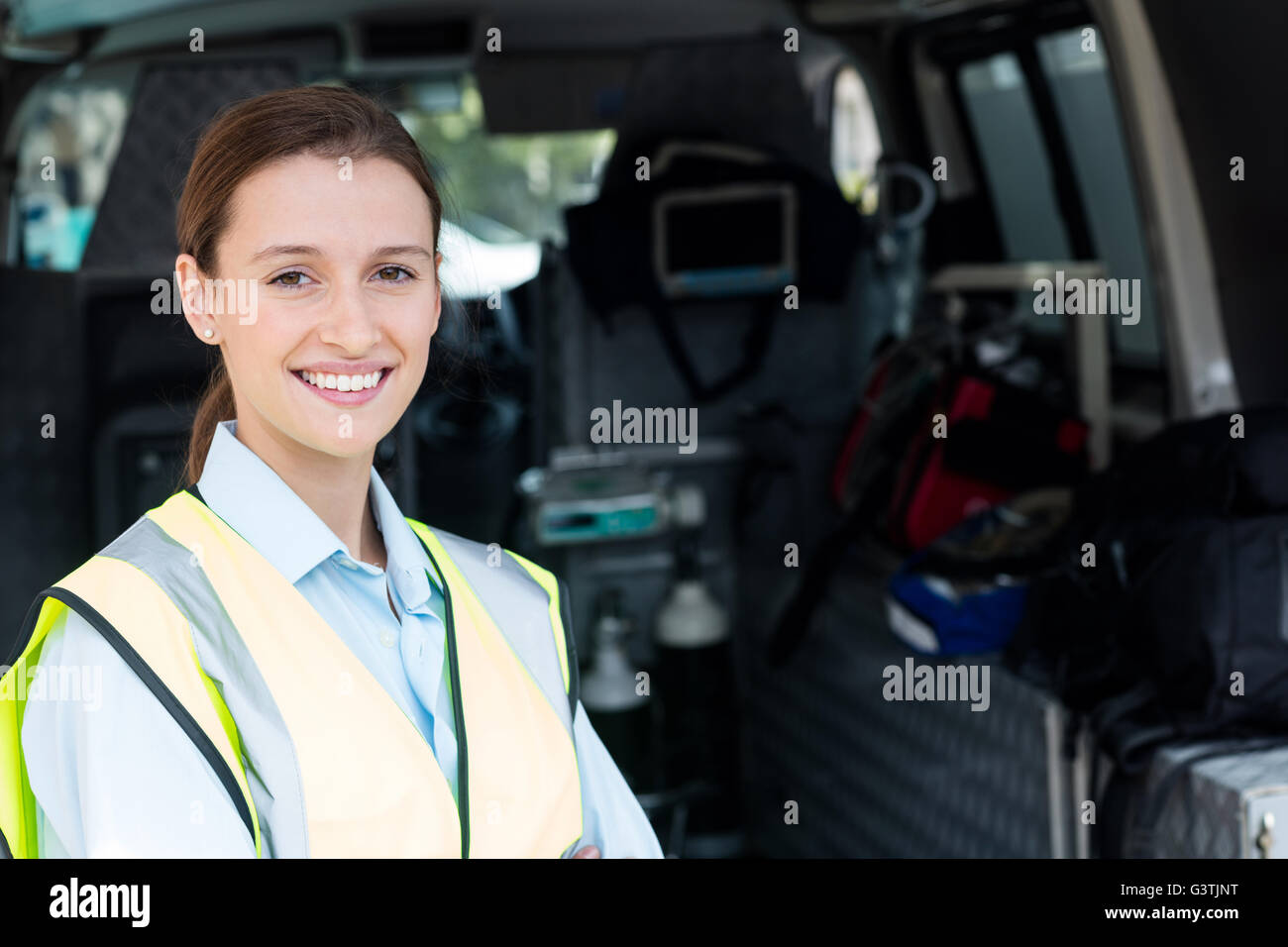 Porträt Ambulancewoman mit Krankenwagen Stockfoto