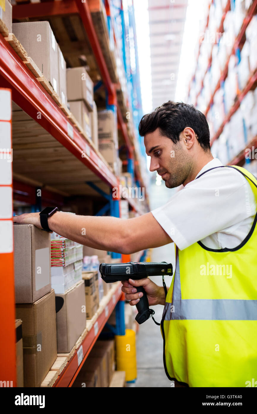 Warehouse Manager mit gelben Mantel Scannen von Barcodes auf box Stockfoto