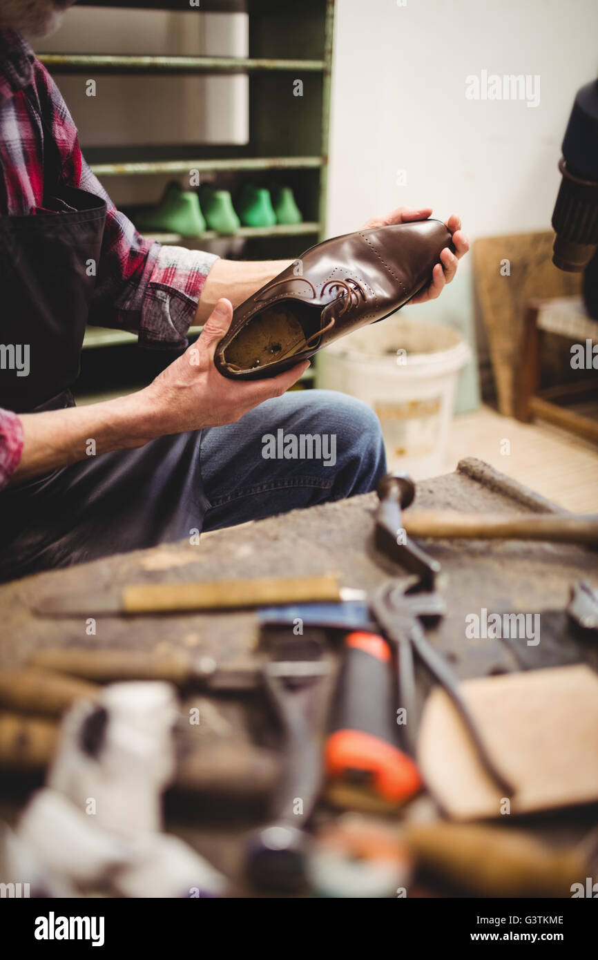 Nahaufnahme von Händen mit einem Schuh Stockfoto