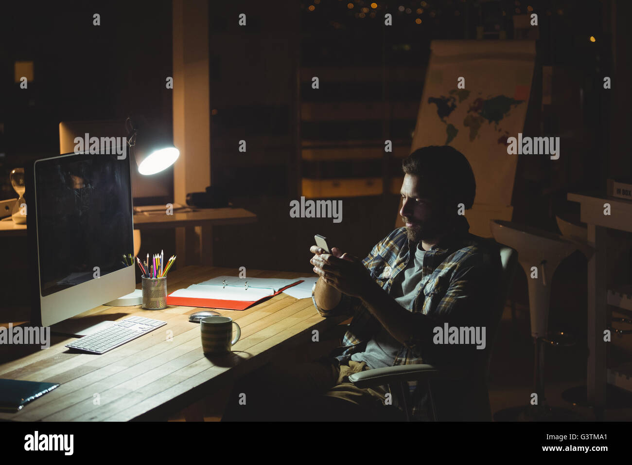 Geschäftsmann mit seinem Smartphone in der Nacht Stockfoto