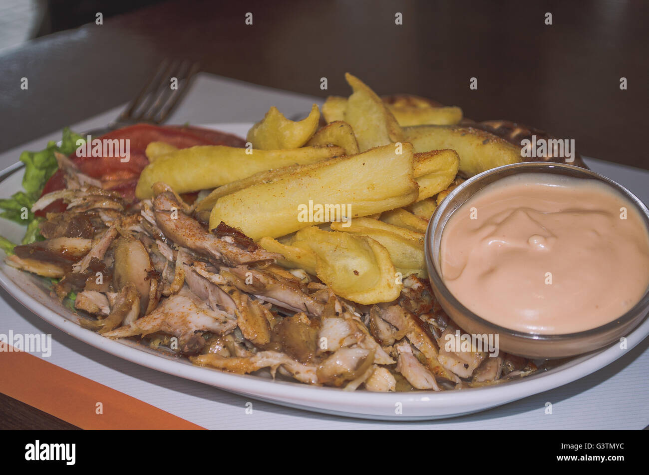 Griechische Gyros auf einem Teller mit Pommes Frites und Gemüse Stockfoto