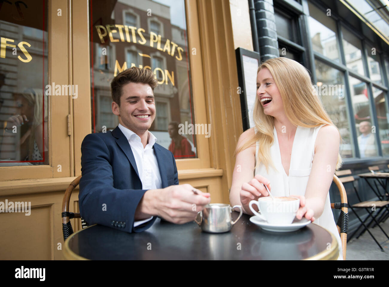 Zwei Freunde sitzen vor einem Café in Covent Garden in London. Stockfoto