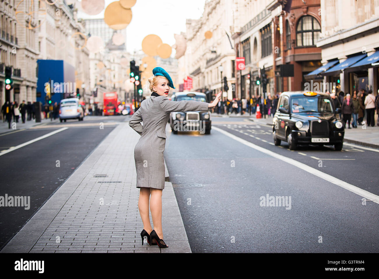 Eine stilvolle junge Frau gekleidet in der 1930er-Jahre Stil Kleidung ein Taxi an der Regent Street in London. Stockfoto