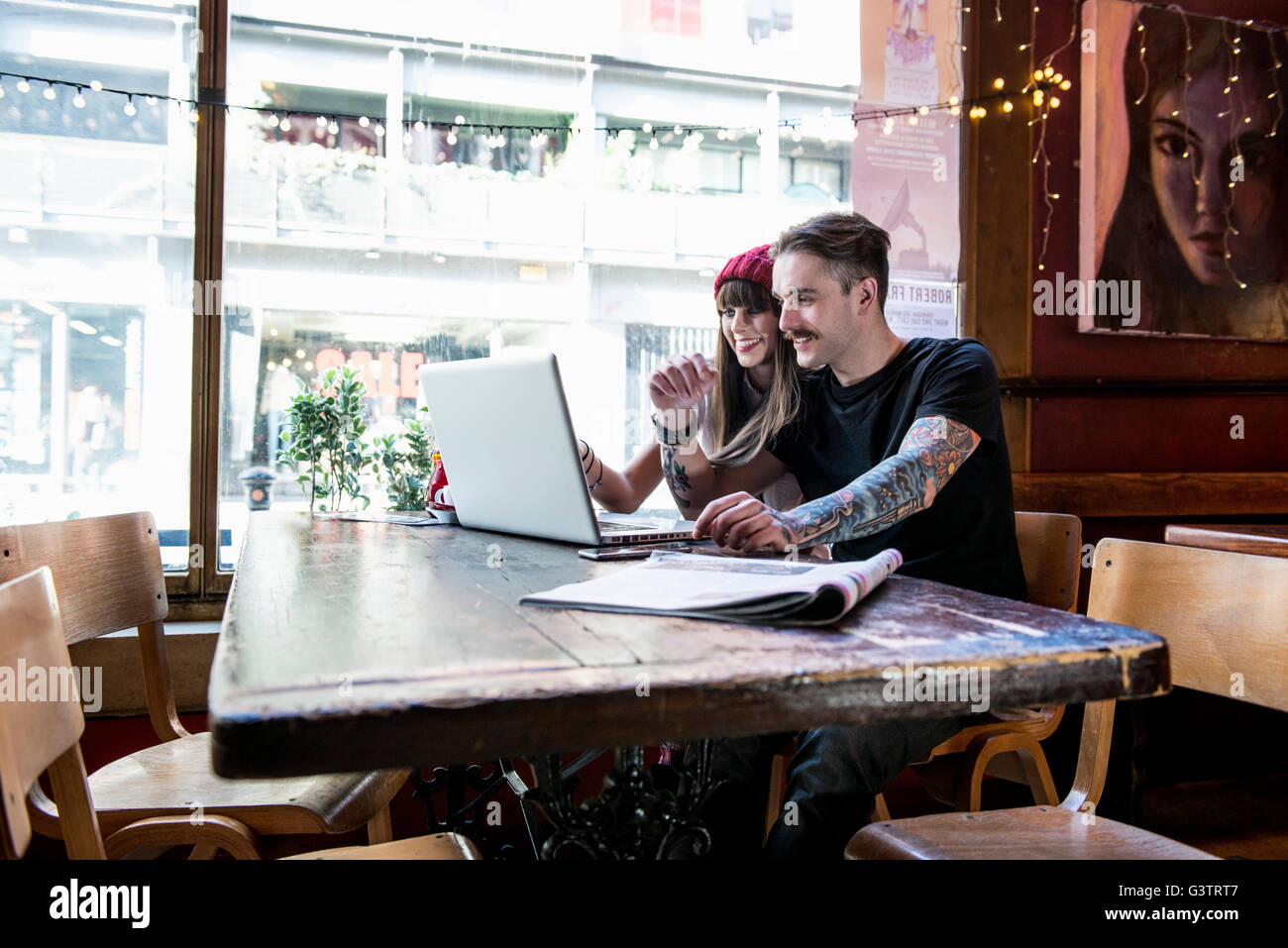 Ein junges Paar, arbeiten an einem Laptop in einem Café in Manchester zusammen. Stockfoto