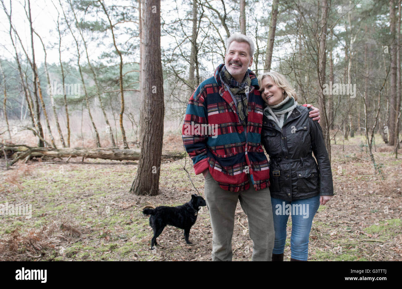 Älteres Paar genießen Sie einen Spaziergang im Wald mit ihrem Hund. Stockfoto