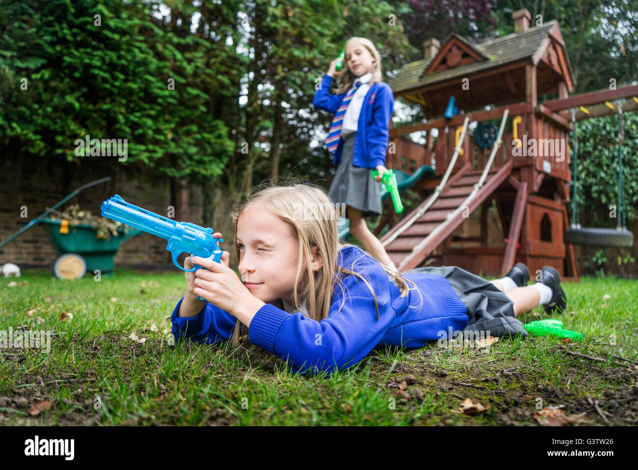 02:10 Jahre alten Mädchen in der Schule einheitliche Holding Wasserpistolen. Stockfoto