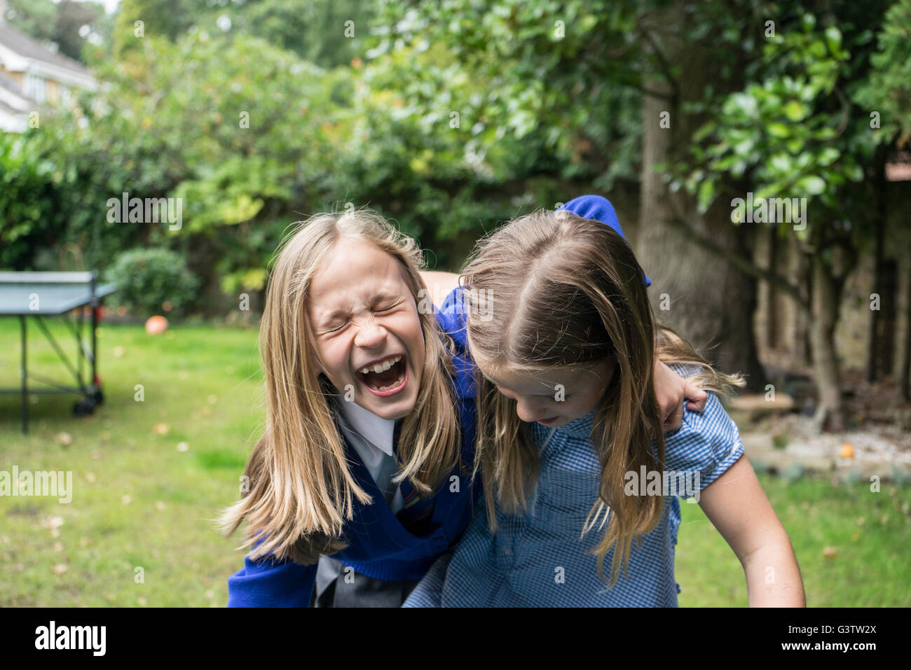 02:10 Jahre alten Mädchen in Schuluniform gemeinsam lachen draußen. Stockfoto