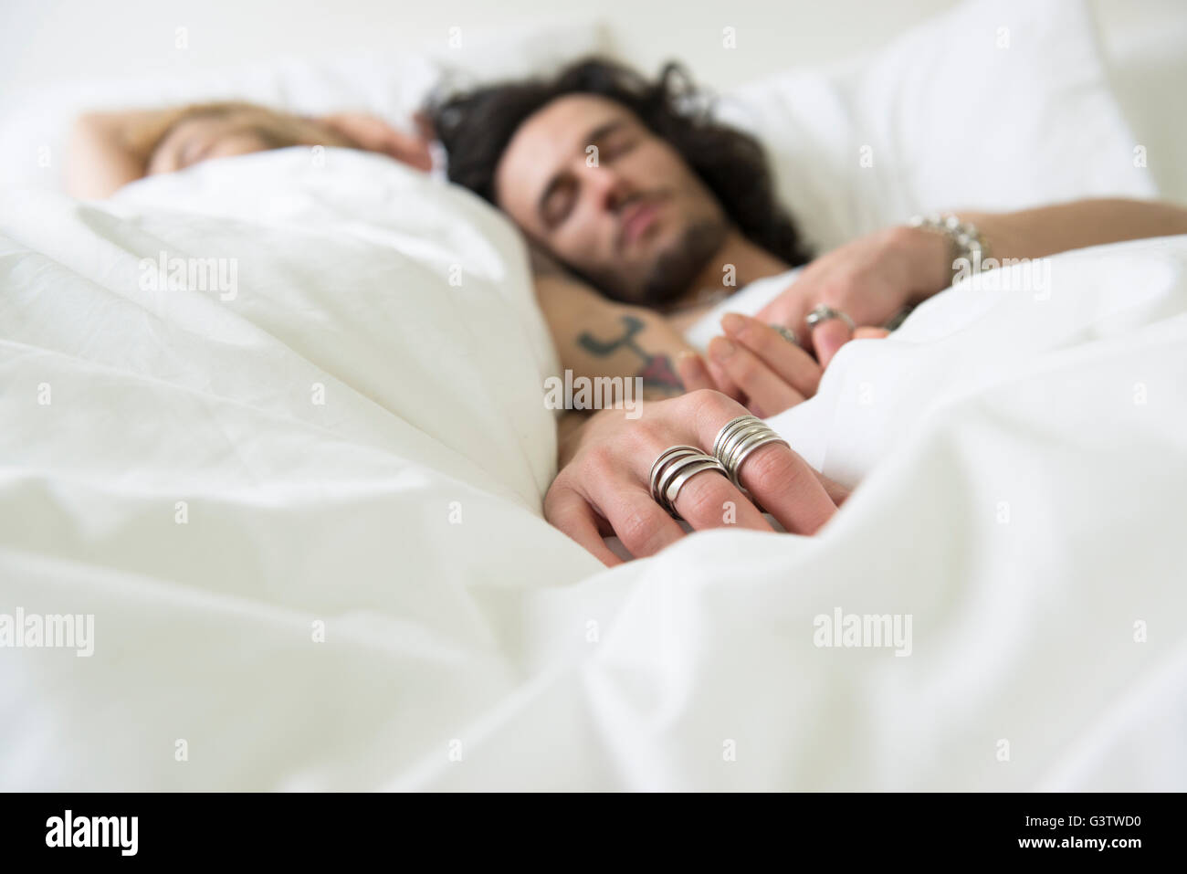 Ein cooles junges Paar gemütlich im Bett mit ihren Augen geschlossen. Stockfoto