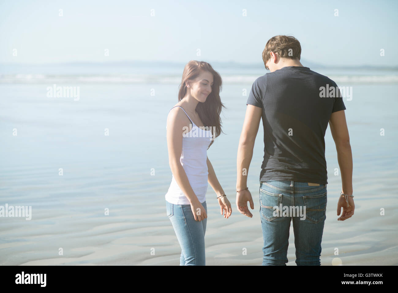 Ein junges Paar, genießen die Sonne am Strand von Porthmadog. Stockfoto