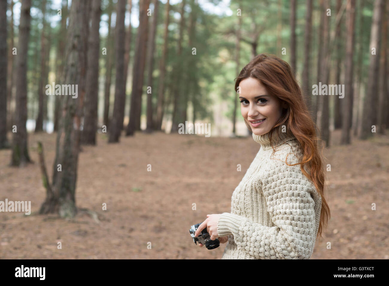 Eine junge Frau mit einem Vintage-Kamera in einem Wald im Herbst. Stockfoto