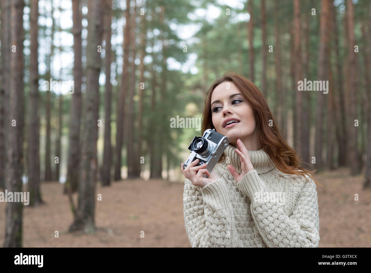 Eine junge Frau mit einem Vintage-Kamera in einem Wald im Herbst. Stockfoto
