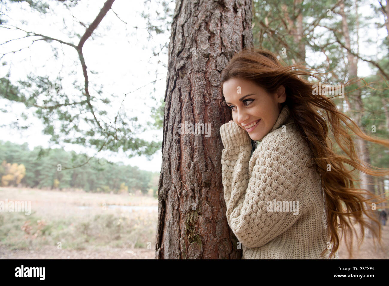 Eine junge Frau, die Zwiesprache mit der Natur auf einem Waldspaziergang im Herbst. Stockfoto