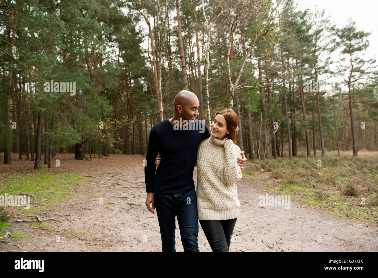 Ein junges Paar Zwiesprache mit der Natur auf einem Waldspaziergang im Herbst. Stockfoto