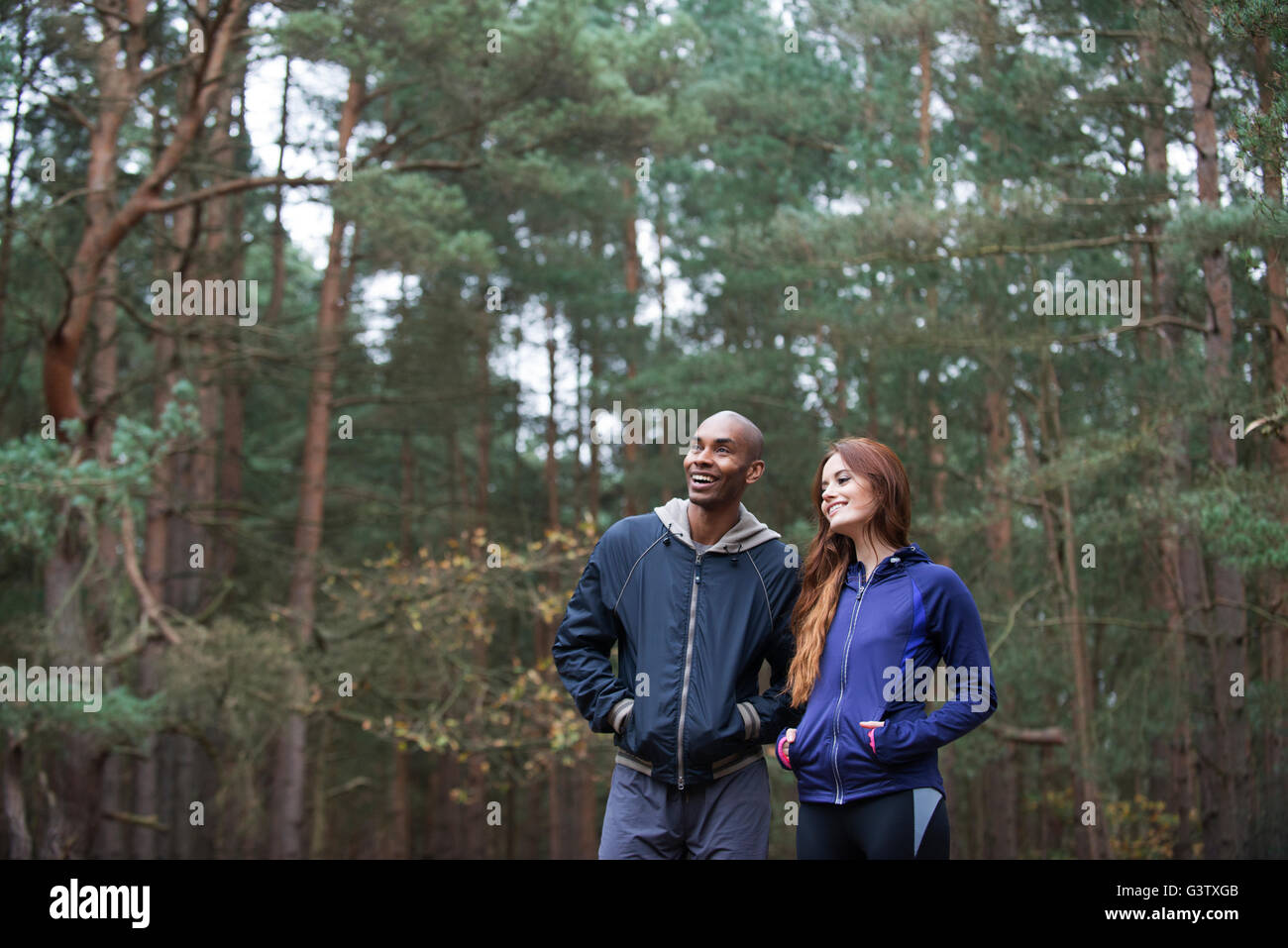 Ein junges Paar genießen der Umgebung des Waldes nach einem Lauf durch den Wald im Herbst. Stockfoto