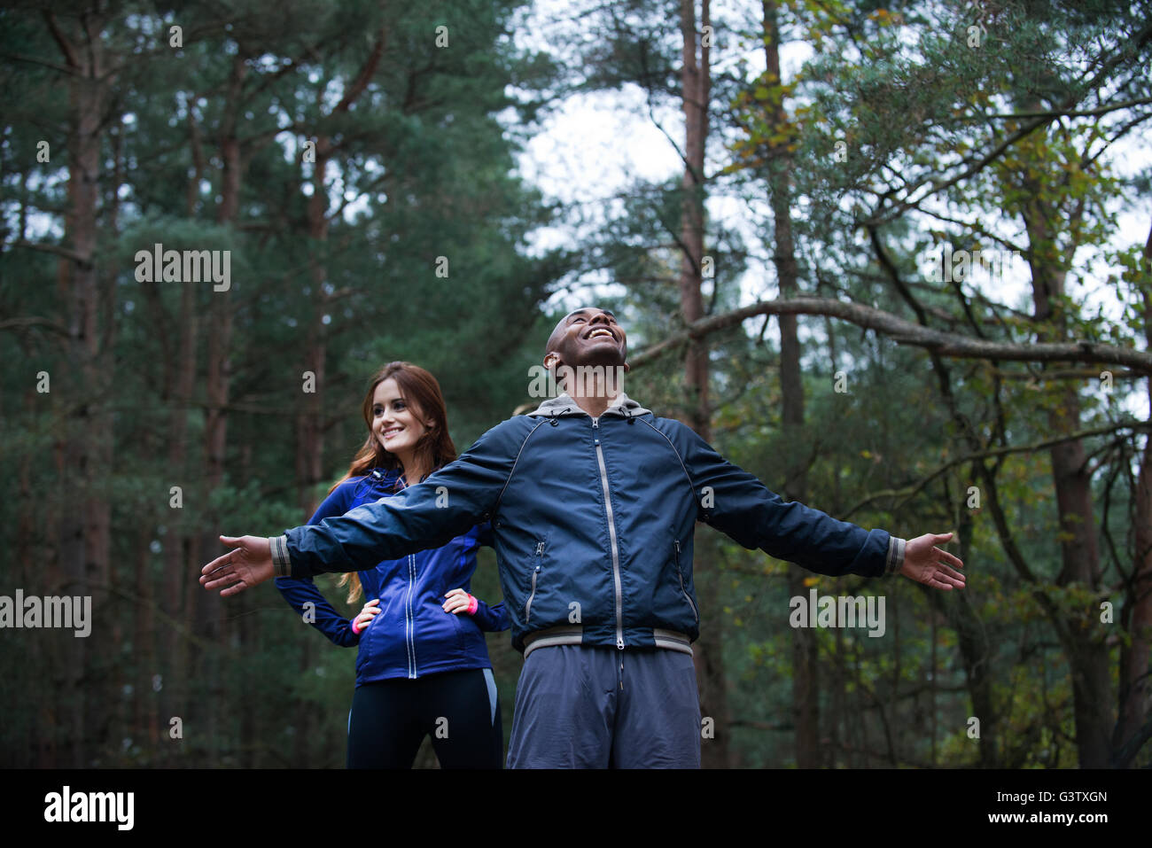 Ein junges Paar genießen der Umgebung des Waldes nach einem Lauf durch den Wald im Herbst. Stockfoto