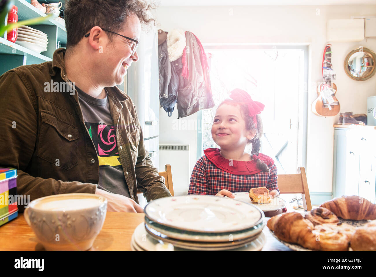 Ein Vater sitzt in seiner Küche unterhielt sich mit seiner 6 Jahre alten Tochter. Stockfoto