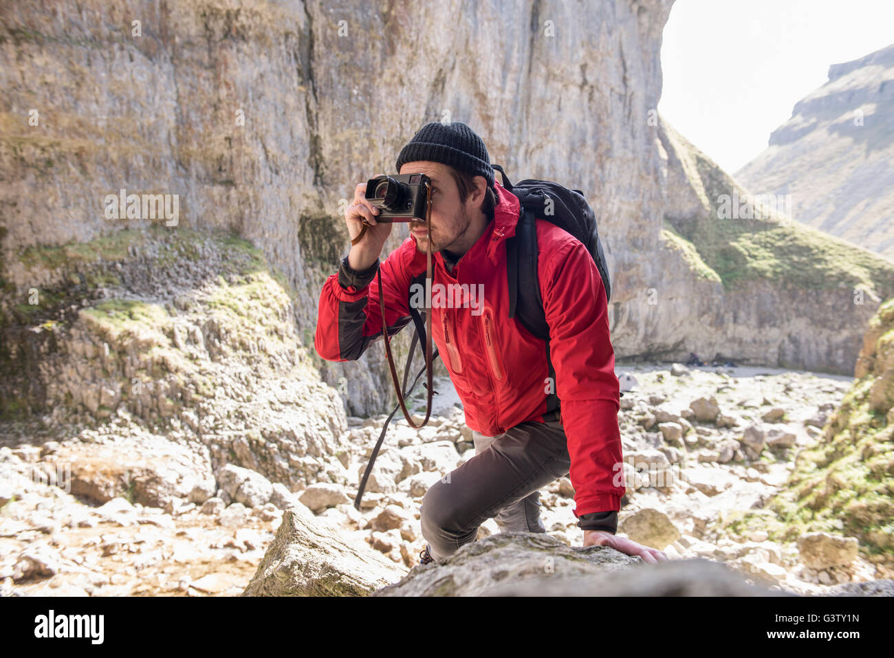 Ein Bergsteiger klettern über die Felsen im unwegsamen Gelände zu fotografieren. Stockfoto