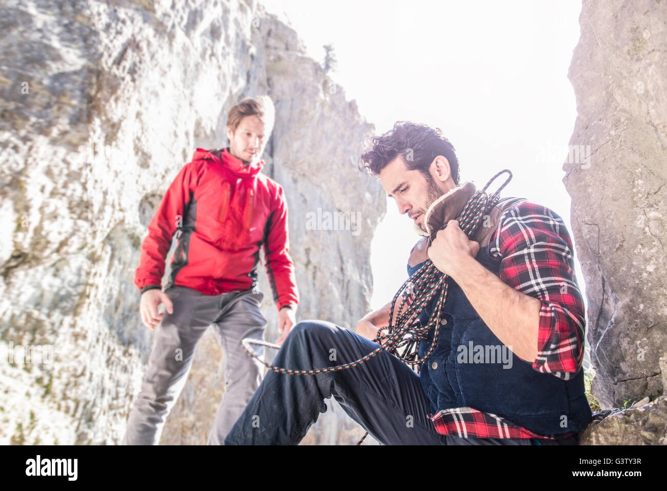 Zwei Bergsteiger ruht während eines Aufstiegs in unwegsamem Gelände. Stockfoto