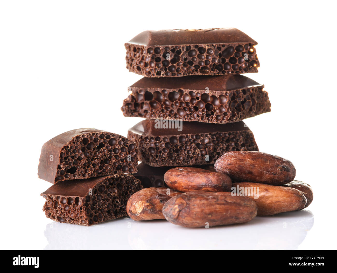 Poröse Schokoladenstücke und Kakaobohnen auf einem weißen Hintergrund hautnah Stockfoto