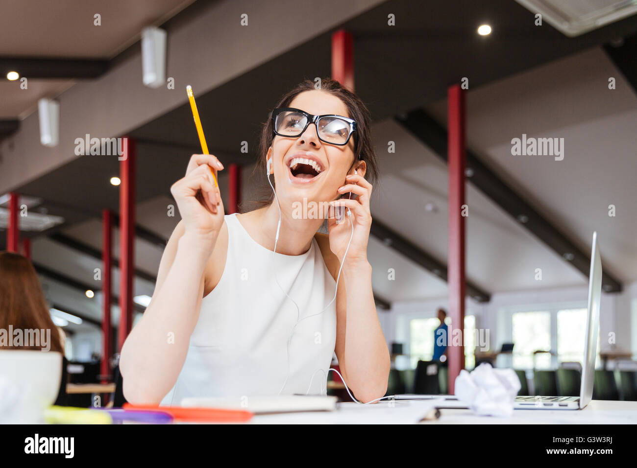 Happy begeistert junge Frau in Gläsern Musikhören im Büro und eine Idee Stockfoto