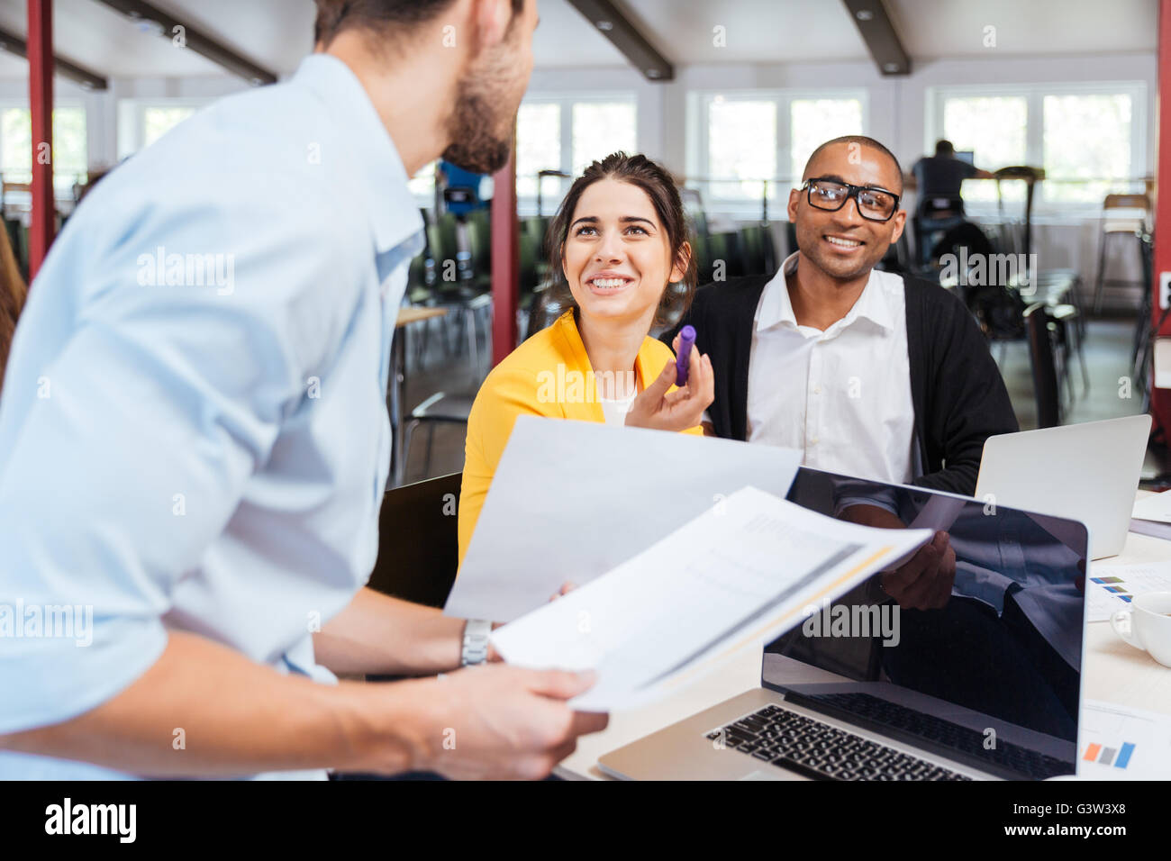 Glückliche junge Geschäftsleute sprechen und gemeinsam im Büro Stockfoto