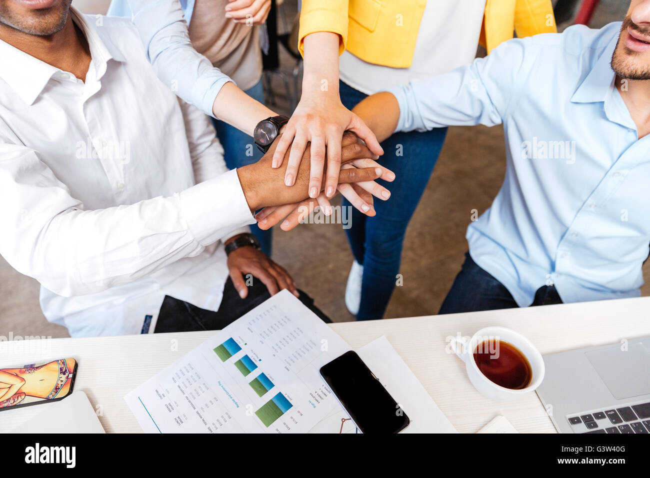 Multiethnische Gruppe von jungen Geschäftsleuten, die Hand in Hand Stockfoto