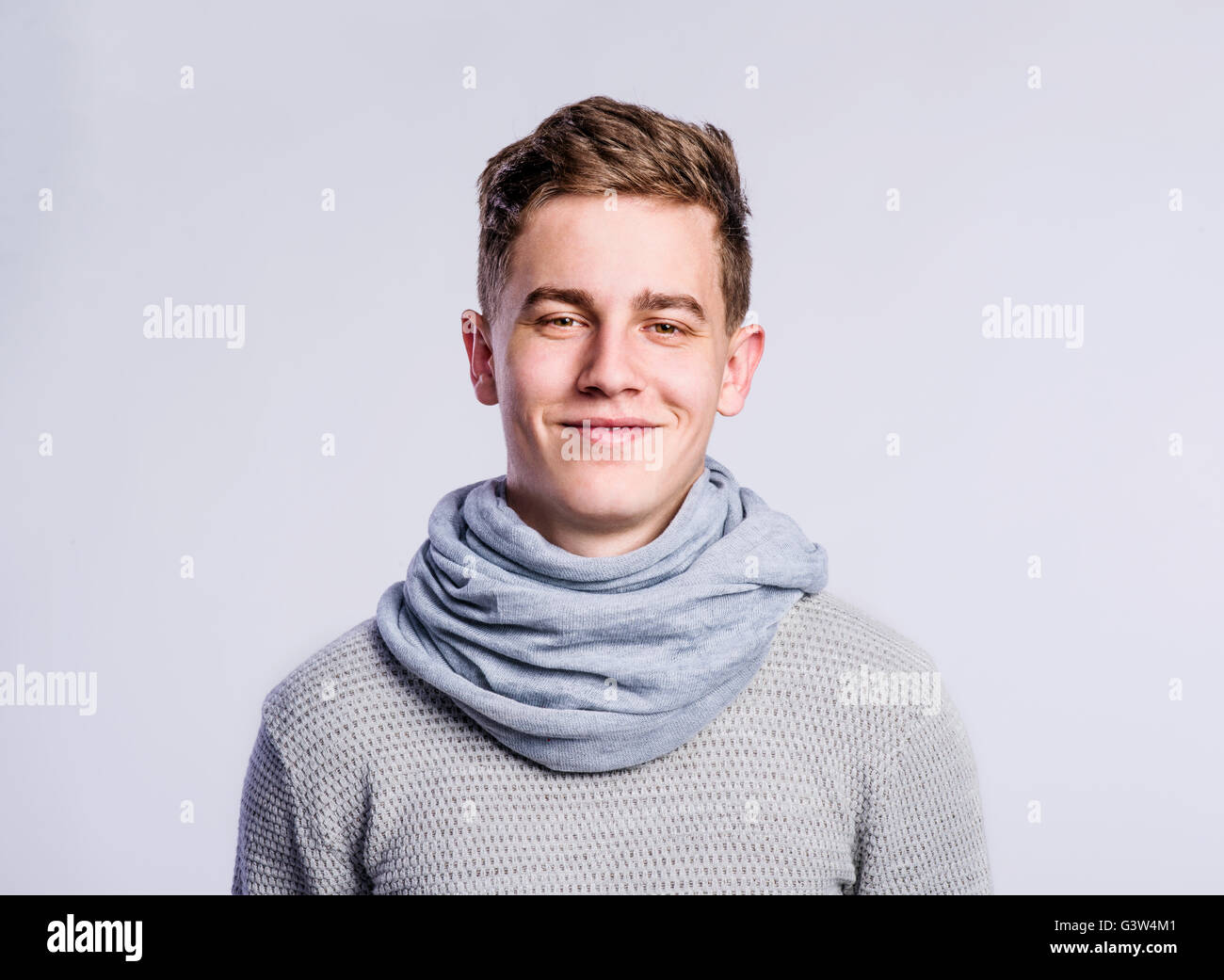Junge im grauen Pullover und Schal, junger Mann, Studioaufnahme Stockfoto