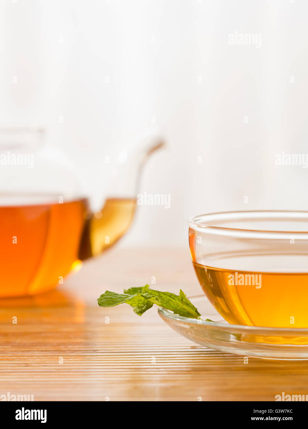 Tee in Tasse mit Minze auf Untertasse Stockfoto