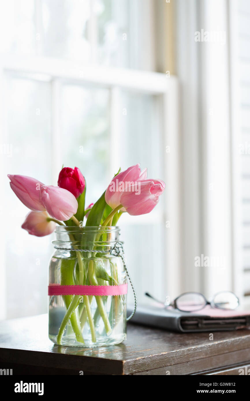 Rosa Tulpen in Vase auf Nachttisch Stockfoto