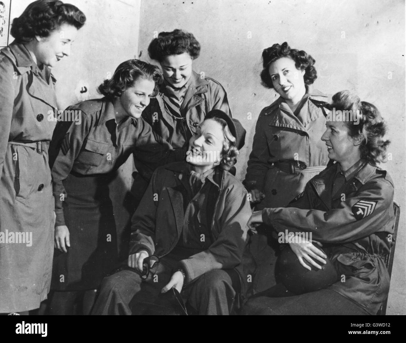 Schauspielerin und Sängerin Marlene Dietrich chats mit einer Gruppe von WAC am Sitz der 12. Armeegruppe, irgendwo in Frankreich. Der Filmstar tourt die kämpfende Bereiche unterhaltsame GI Joes und Janes. Stockfoto