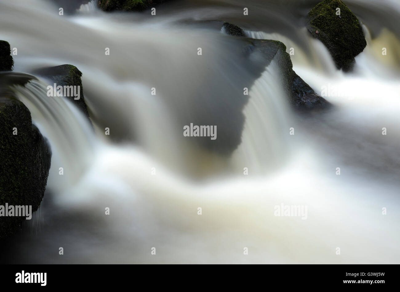 Wasser Kaskadierung über Felsen, Langzeitbelichtung, die Erfassung der Bewegung und Bewegung am Golitha Wasserfälle Bodmin Moor Stockfoto