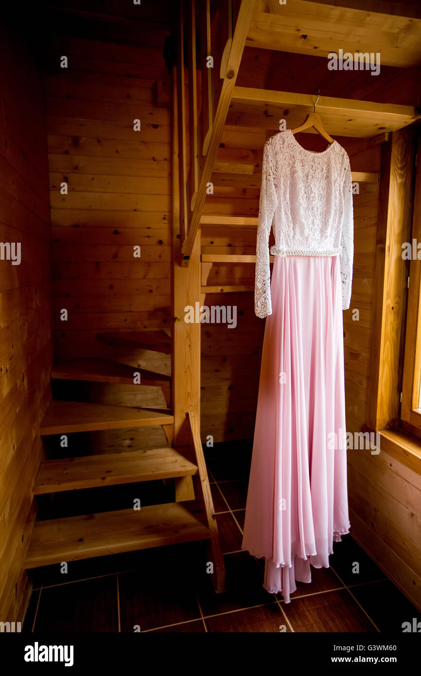 Nahaufnahme des Hochzeitskleides hängen an Holztreppen Stockfoto