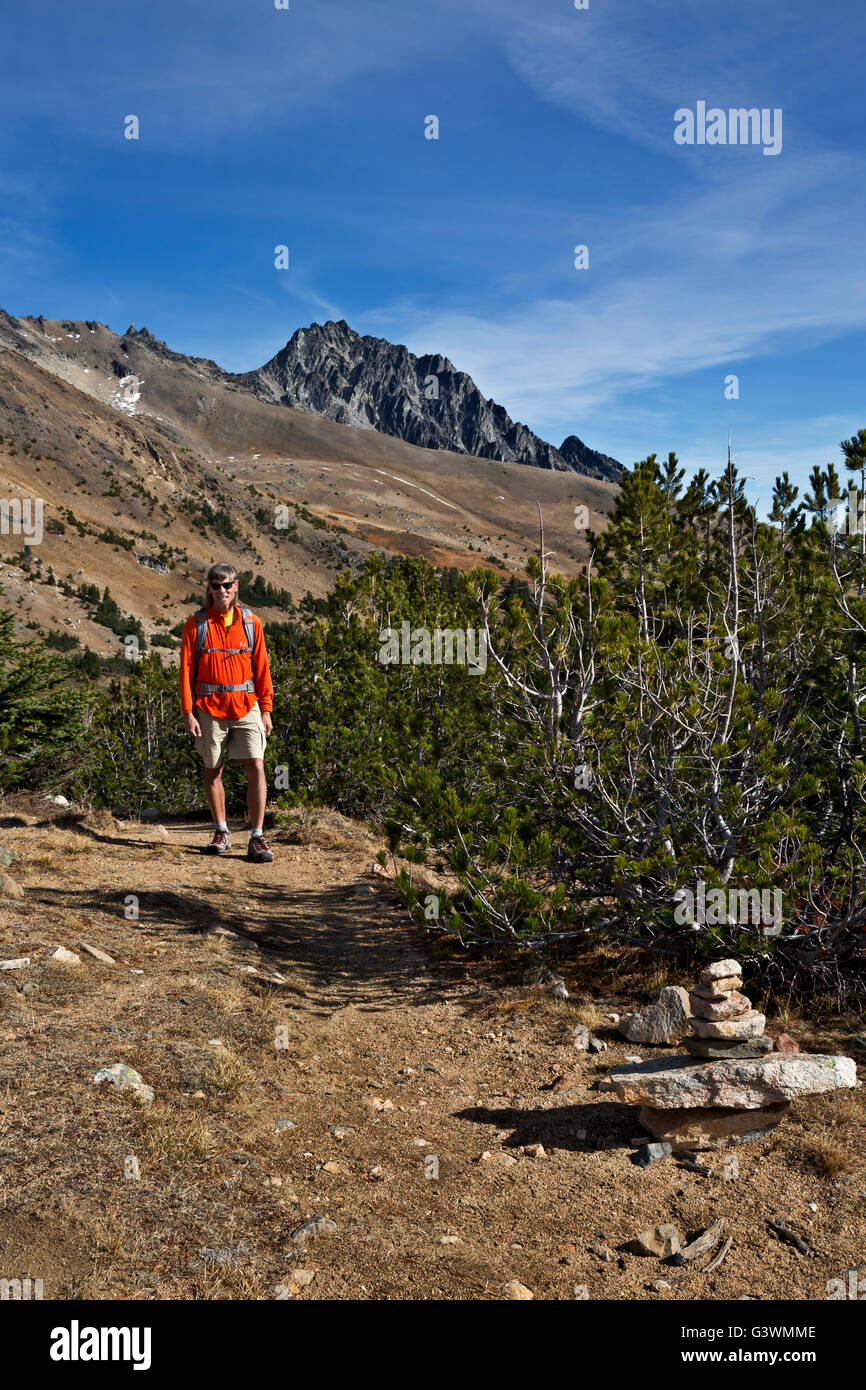WASHINGTON - Wanderer nähert sich einem kleinen Cairn Kennzeichnung Windy Pass mit Kaschmir Berg jenseits der alpinen Seen-Wildnis. Stockfoto