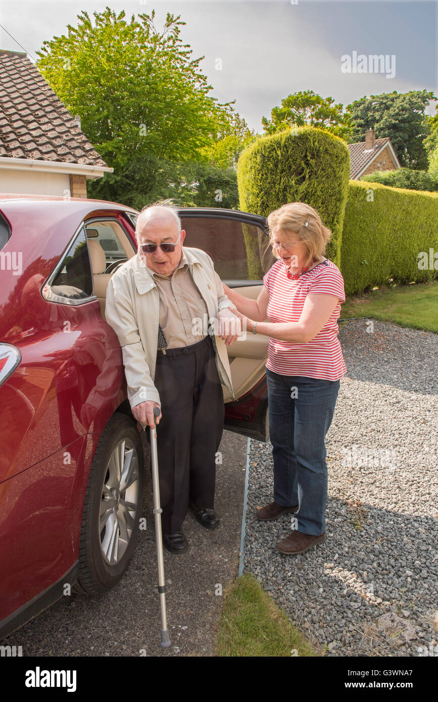 Der Mensch in seinen Neunzigern Hause motor mit dem Auto anreisen, nach möglicherweise ein Krankenhaus oder Ärzte Termin mit Tochter oder Betreuer. Stockfoto